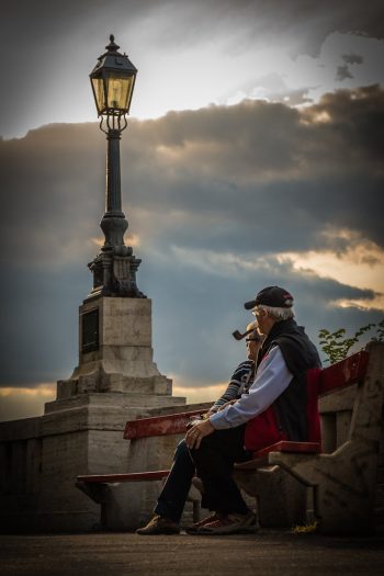 Photo by Pixabay Seniors enjoying a quiet moment on a park bench during a serene sunset.